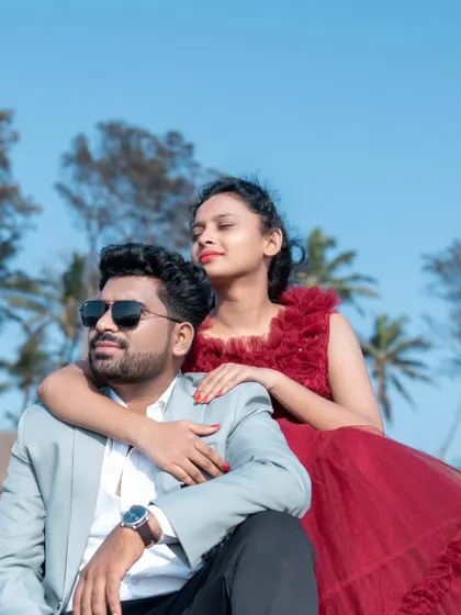 A sun-kissed moment by the sea. The groom's light blazer and the bride's ruffled red gown create a chic and modern look for their pre-wedding shoot.