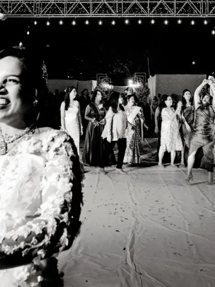 The bride dances with joy during the bouquet toss. This black and white shot captures her happiness and the energy of the moment.