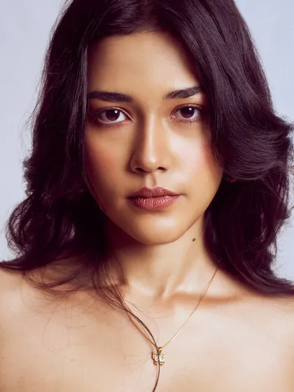 A stunningly simple beauty portrait. The makeup is clean, focusing on flawless skin and softly defined features, creating a timeless and captivating image.