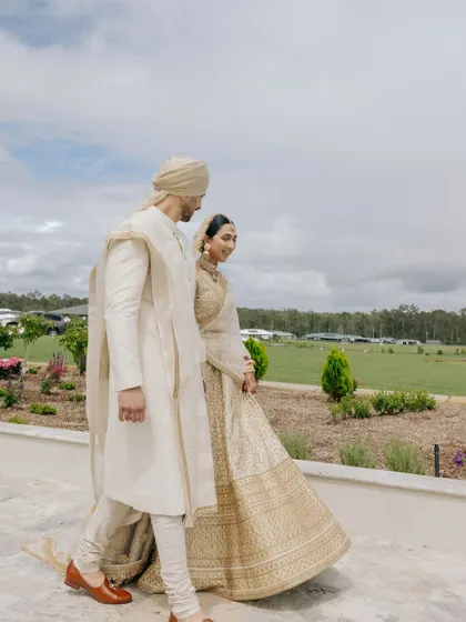 A candid shot of Manchal and Luca walking together at their Australian countryside wedding, capturing a quiet moment against a vast, open landscape.