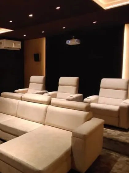 The seating view of the same bespoke cinema. We used a combination of plush recliners and a comfortable sofa to accommodate both serious viewing and casual family time. The tiered seating ensures everyone has an unobstructed view of the screen.