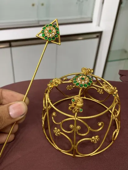 A side view of the green stone bun cover, showcasing its elegant structure and the delicate details of the gold-plated frame.