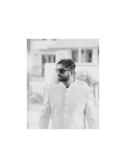 A cool, black and white portrait of the groom in his sherwani and sunglasses. This shot has a modern, editorial feel.