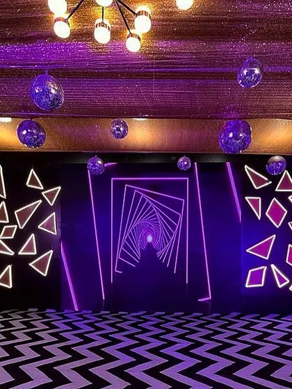 For a futuristic Sangeet, I designed this immersive photo-op area. It features geometric neon light installations and a patterned floor to create a visually striking, high-energy space.