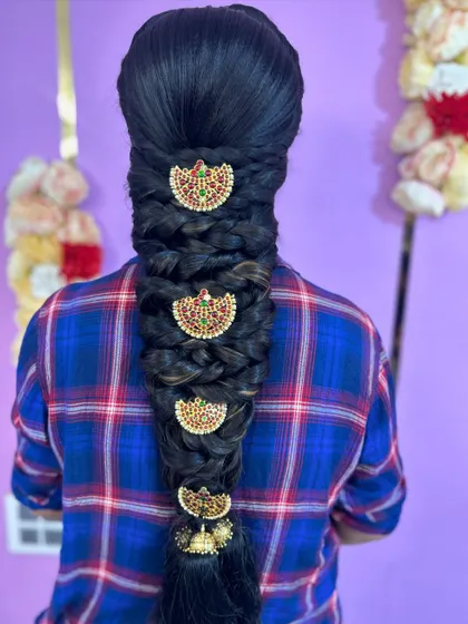 A classic five-strand braid decorated with traditional temple-style `jhumki` accessories. This style is very popular for South Indian pre-wedding ceremonies.