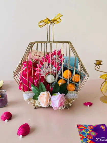 This unique metal hexagon birdcage box is a true statement piece. It's filled with laddoo candles, flowers, and other festive items.