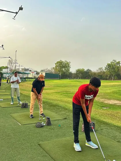 A young golfer in a red shirt prepares to hit a shot, representing the next generation of players at Hamoni.