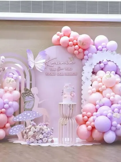 A dreamy and ethereal pastel-colored balloon decoration with butterfly and mushroom props, perfect for a fairy-themed party.