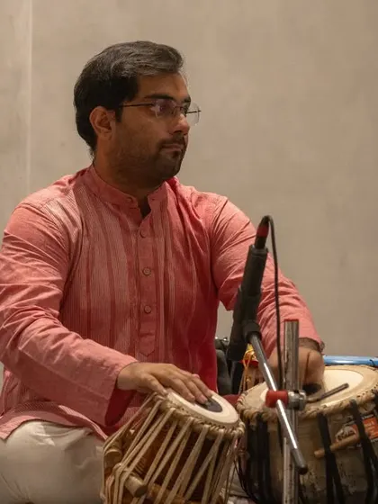 A side profile during a performance, showing my focus on the intricate bols and the conversation between the dayan and bayan drums.