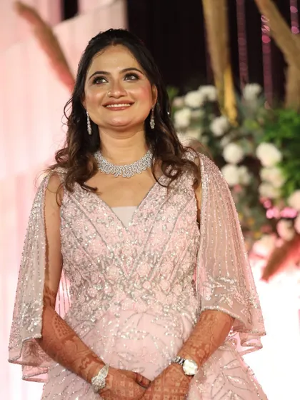 A radiant smile from the bride at her reception. The makeup features a flawless base and a soft pink lip to match her elegant attire.