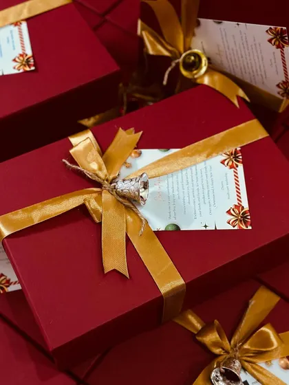 A close-up of one of our festive corporate gift boxes, featuring a custom-printed card and a decorative bell for a personalized touch.