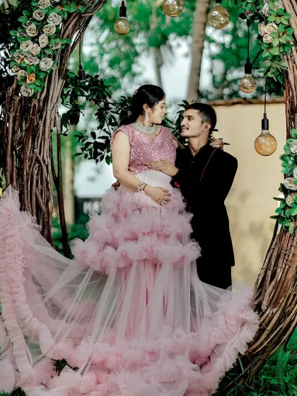 A romantic couple's maternity shoot featuring our popular pink ruffle gown.
