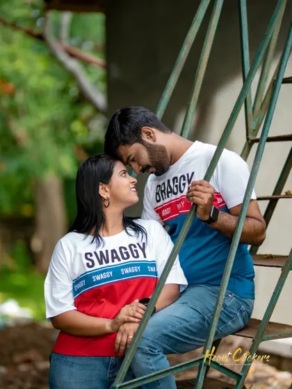 An intimate and playful moment on a set of stairs. The couple's matching t-shirts and loving gaze make this a sweet and relatable pre-wedding photo.