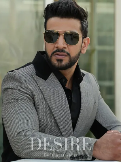 A close-up portrait in the grey and black color-blocked blazer. The black lapels and shoulder panels create a powerful and sophisticated look.