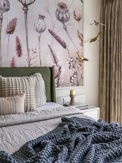 Another angle of the sage green master bedroom, highlighting the custom wallpaper, layered bedding, and decorative wall birds that add a touch of whimsy.