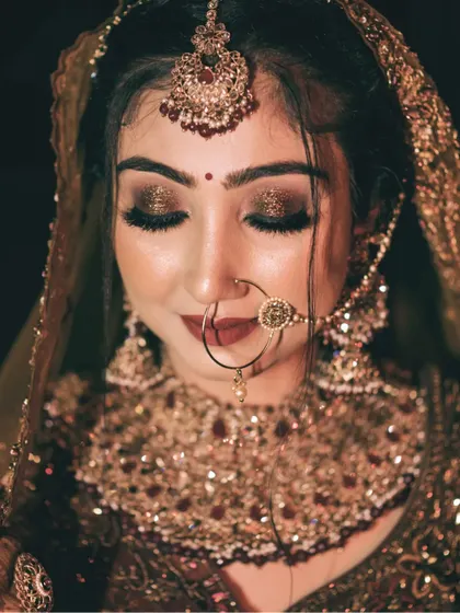 A stunning close-up of the bride, highlighting her glamorous eye makeup and bridal jewelry.
