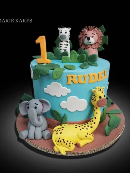 This jungle-themed cake is perfect for a little one's birthday. It features cute fondant animals like a giraffe, elephant, lion, and zebra, all ready to party.