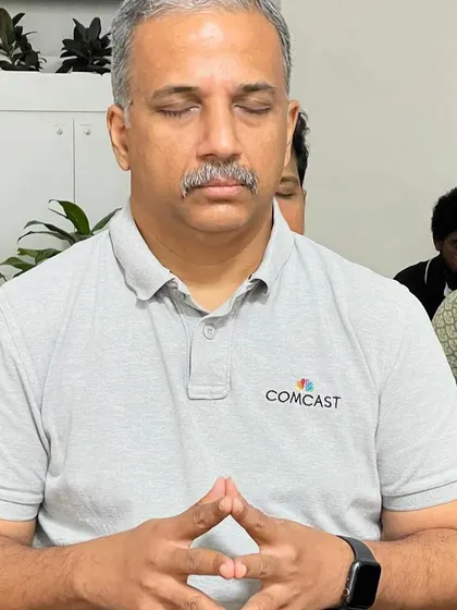 A senior employee at Comcast holding a mudra for focus. These simple techniques are accessible to everyone and can be integrated into the workday to enhance mental clarity and reduce stress.