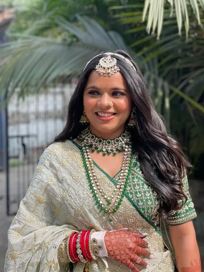 A simple and elegant open hairstyle with soft waves, paired with a traditional mathapatti. This look is perfect for the bride who wants a natural and radiant wedding day look.