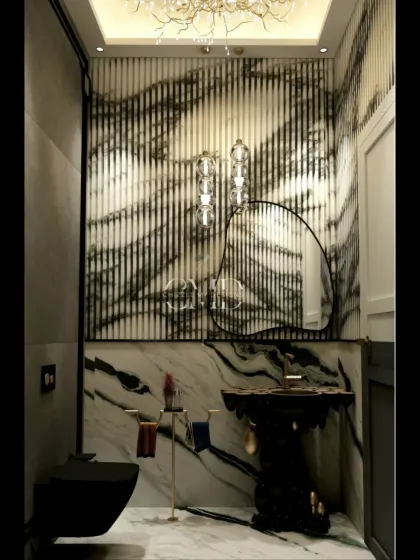 This powder room makes a bold statement with dramatic black marble, a sculptural black pedestal sink, and a stunning branch-like chandelier.