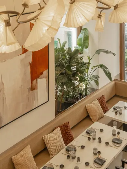 An overhead view of the booth seating, highlighting the mix of textures in the cushions and the soft glow of the unique, sculptural light fixture.