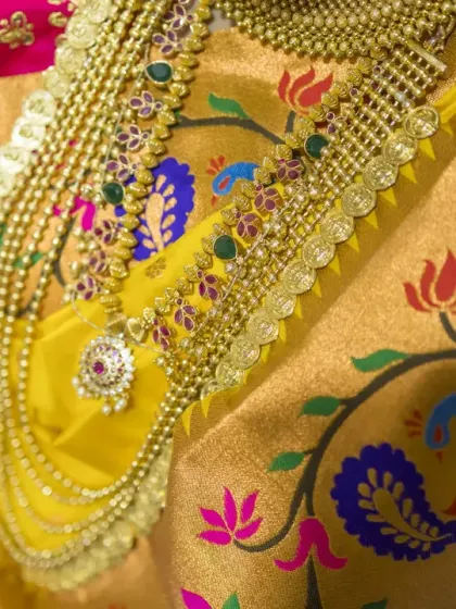 A detailed shot of the bride's traditional layered necklace against the backdrop of her vibrant Paithani saree.