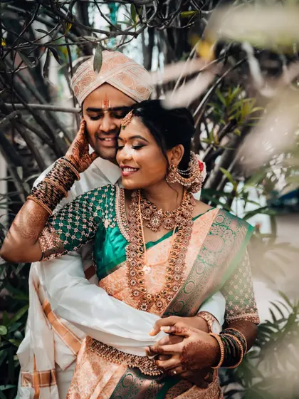 An intimate portrait of a South Indian couple, with the groom gently holding his bride, capturing their deep connection.