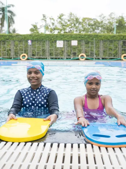 Two friends practicing together. Our classes not only teach swimming but also help children develop social skills and build friendships.