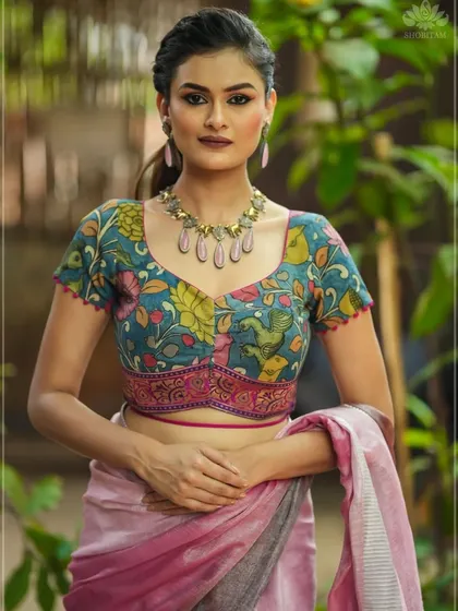 This is one of my signature Pen Kalamkari blouses. The intricate floral and bird motifs are hand-painted, and the unique cut of the blouse makes it a contemporary piece of wearable art. It’s shown here paired with a simple linen saree to let the blouse shine.