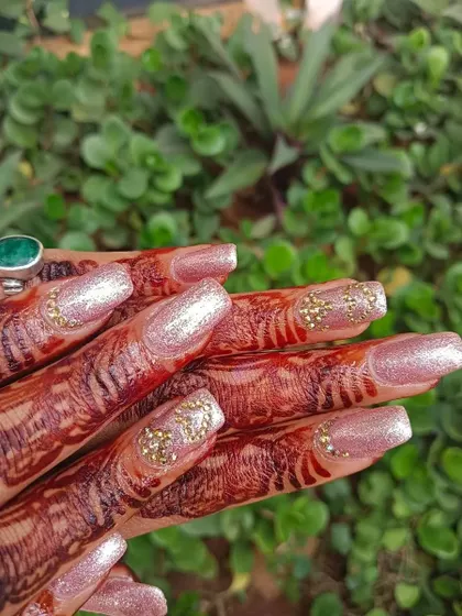 These engagement nails feature a beautiful pink glitter base. To make them extra special, I added a delicate cluster of gold stones on the accent nail, which catches the light beautifully.