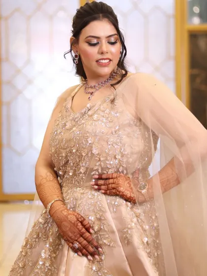 A beautiful pose by the bride in her beige gown, showing off the full silhouette and her elegant makeup.