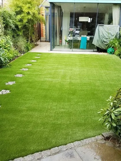 I integrated cobblestone stepping stones into this artificial lawn, creating a charming pathway that leads to the house. This shows how you can blend functional paths with the beauty of a perfect green lawn.