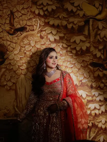 A lovely portrait of the bride against a beautifully lit, artistic background. Her soft makeup and elegant outfit create a romantic feel.