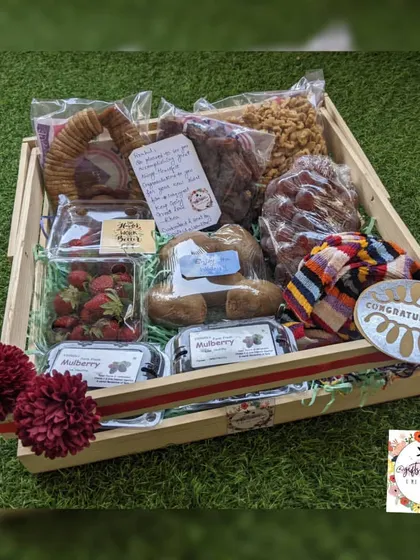 A flat-lay image of the complete winter hamper, showing the beautiful arrangement of fresh fruits, dry fruits, and the congratulations plaque for his new film.