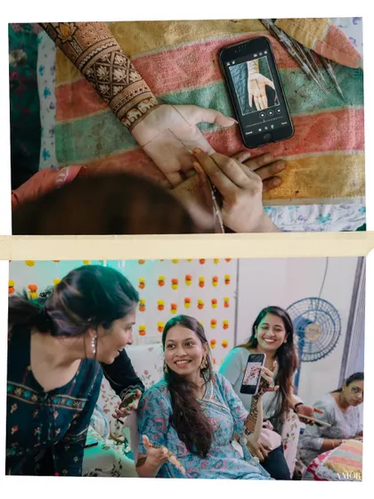 A fun, meta-moment where the bride shows her henna artist a design on her phone. It's a candid look into the process of the Mehendi application.