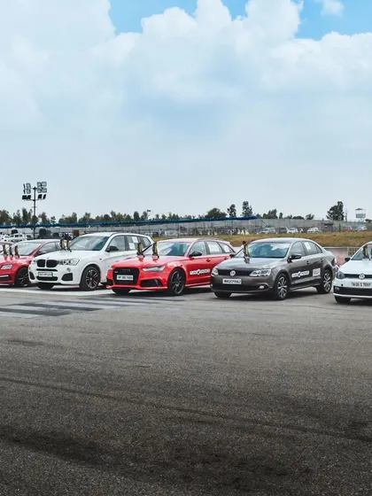 A lineup of performance cars, including Audis and Volkswagens, waiting for their turn on the strip. The sheer volume and variety of vehicles on display is a spectacle in itself.