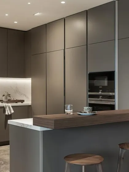 This angle showcases the integrated appliances and handle-less cabinetry, which contribute to the kitchen's clean and uncluttered look. The breakfast bar provides a casual spot for morning coffee.