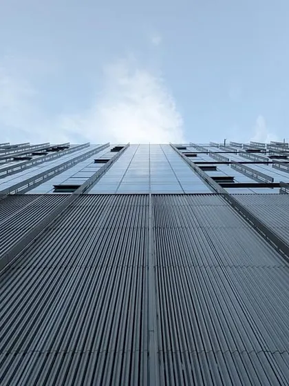 A dramatic upward shot of the facade at the Godrej Koregaon Park campus. The image captures the immense scale and clean, modern lines of this 1.9 million sq. ft. corporate development in Pune.