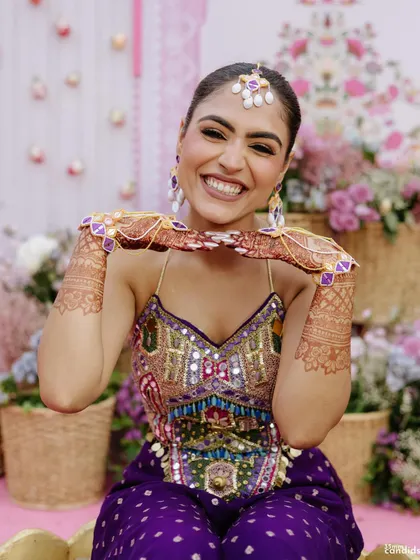 A happy bride showing off her sleek, long braid during her Mehendi ceremony. This style is perfect for keeping long hair managed and beautiful.