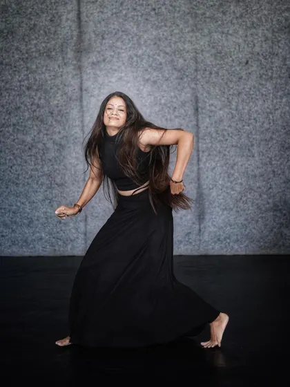 A powerful, grounded stance showing the strength and control that comes from years of dance training.