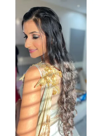 The right makeup enhances your power. This side profile highlights the soft contouring and the elegant half-up hairstyle, perfect for a glamorous sangeet function.