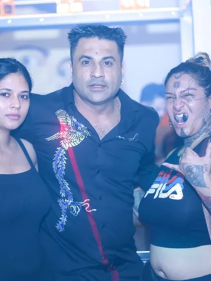 A diverse group of partygoers, including the uniquely tattooed Tattoographer Karan, enjoying the night.