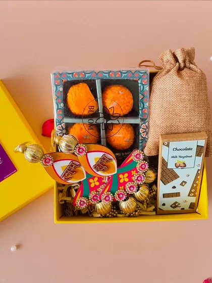 A close-up of the festive items inside the yellow gift box, perfect for a budget-friendly yet traditional gift.
