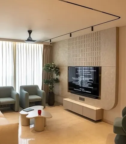 The living room in the Oberoi Sky City apartment, featuring a clean, contemporary aesthetic. I used soft, curved furniture and a textured feature wall to create a space that feels modern yet comfortable.