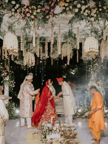 Under a canopy of flowers and twinkling lights, the wedding ceremony unfolds. This night mandap was designed to feel intimate and magical, a sacred space for the couple to make their lifelong promises.