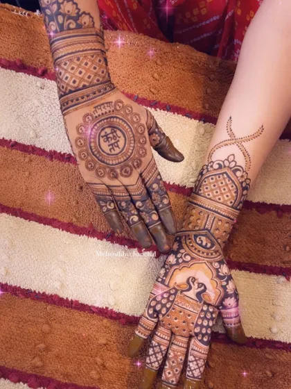 A still image capturing the full detail of the traditional design with peacocks, elephants, and personalized names.