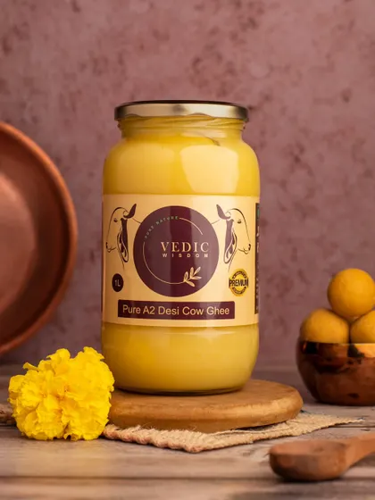 A product shot for Vedic Wisdom's Pure A2 Desi Cow Ghee. We styled it with traditional elements like a copper vessel and marigold flowers to convey purity, tradition, and quality.