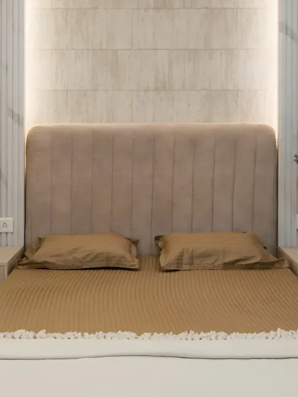 Luxury lies in the details. This bedroom features a plush, channel-tufted headboard in a soft beige fabric, with backlighting that creates a warm and inviting glow.