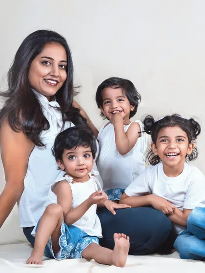 A mother and her three children, full of laughter and smiles. This photo captures the beautiful chaos and joy of a happy family.