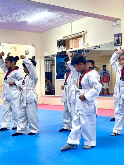 Young students practicing a high block, building a strong defensive foundation.